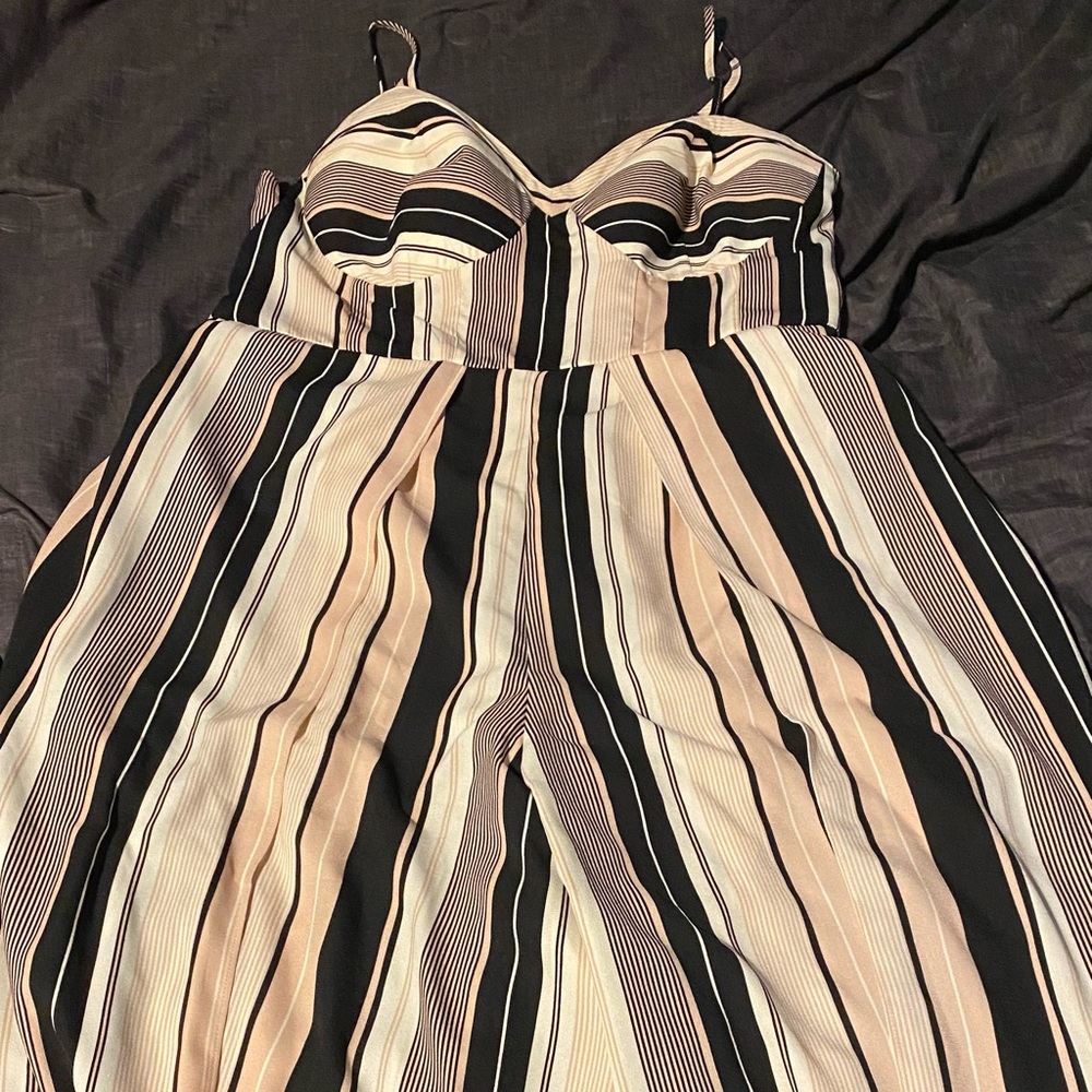 One piece, Jump suit, pockets, long pant legs. Colors light pink, white, black.
